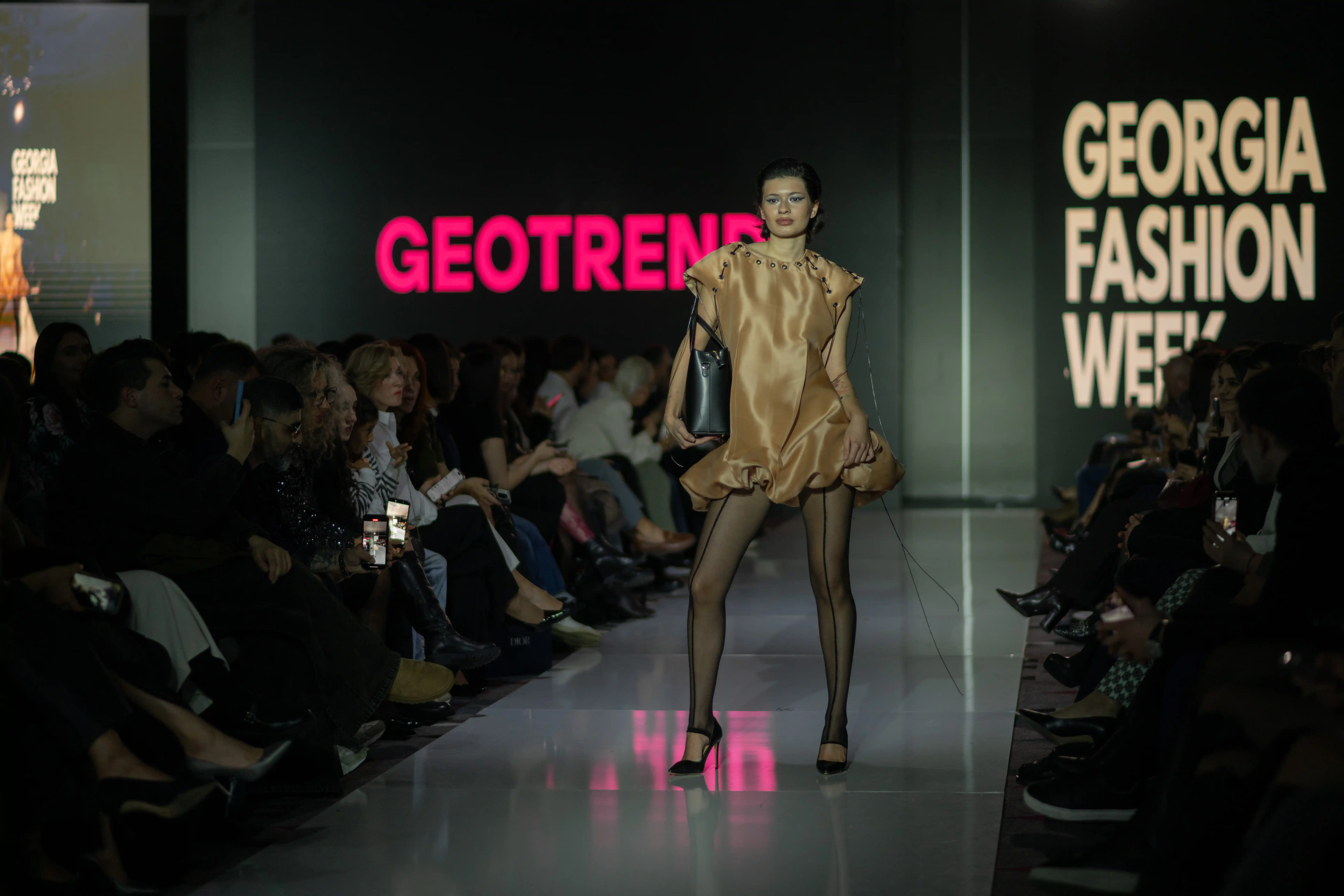 ოქროსფერი აბრეშუმის კაბა პოდიუმზე